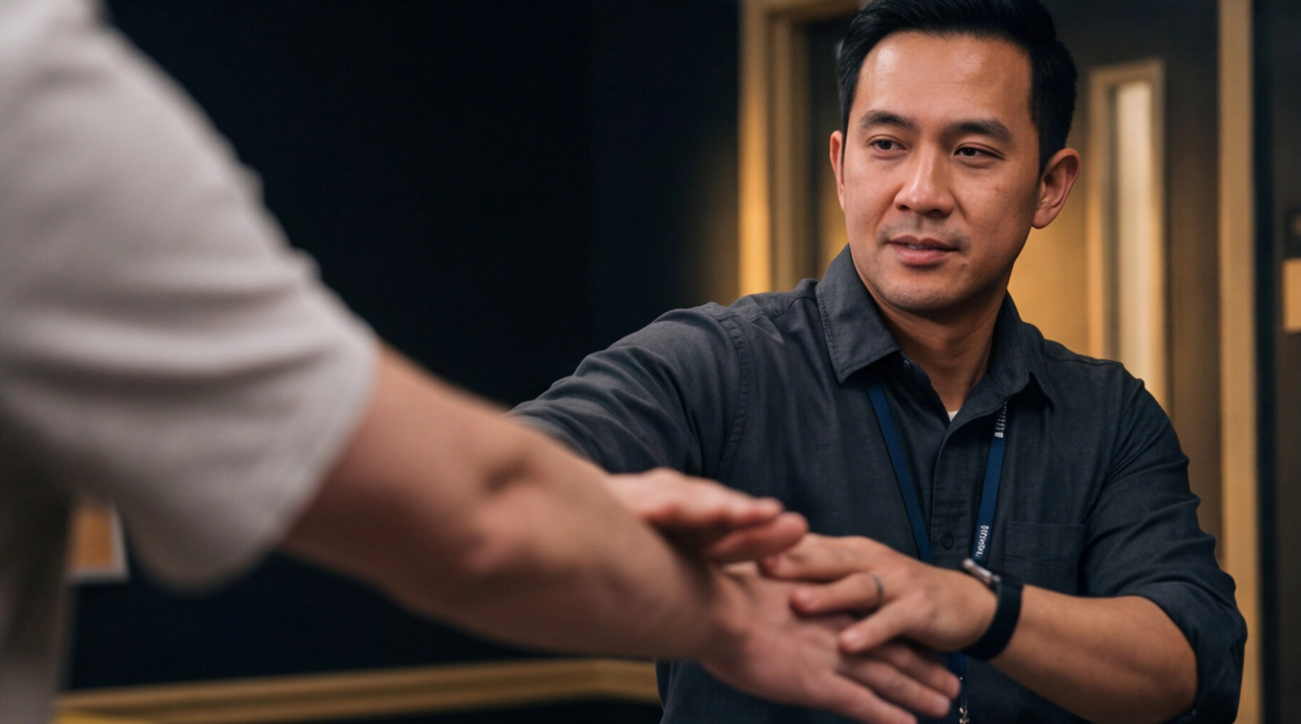 A participant practises a hand-control technique with a training partner during a self-defence session.